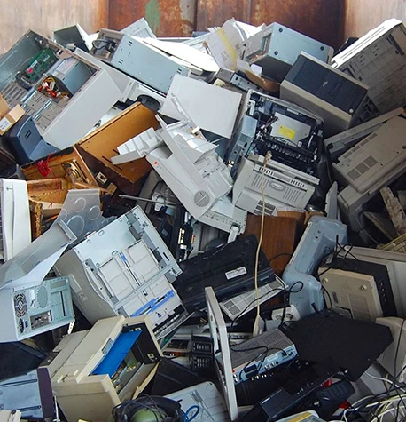 Large pile of discarded electronic devices including computers and TVs.